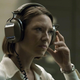 Anna Torv wears headphones and listens intently in a scene from Mindhunter.